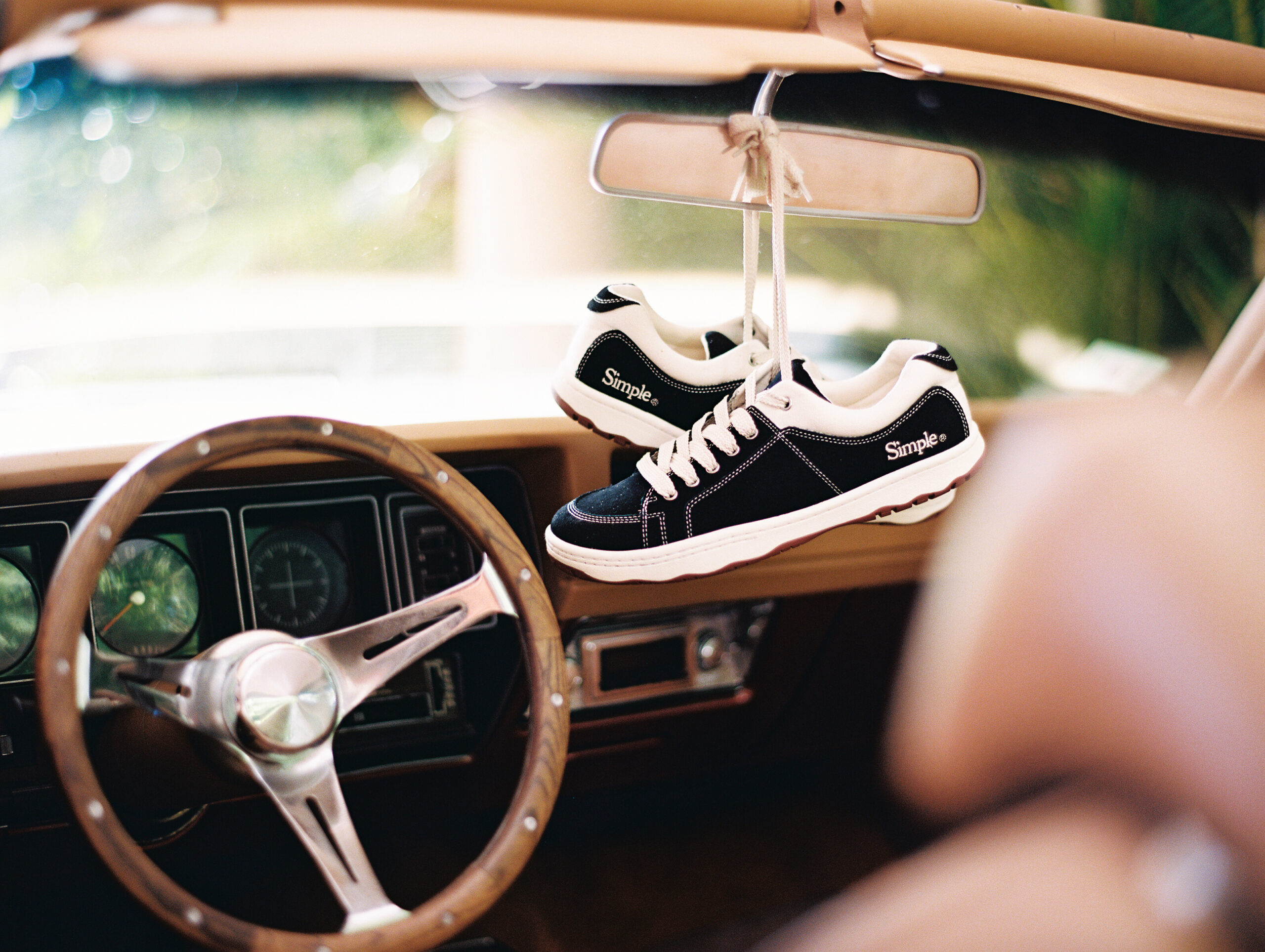 Shoes hanging in classic car mirror shot on film